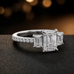 Side view of an emerald cut three-stone lab-grown diamond engagement ring in 18kt white gold with diamond shoulders