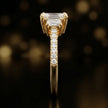 Side profile of an emerald cut three-stone lab-grown diamond engagement ring in 18kt yellow gold showing the diamond band
