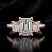 Front view of an emerald-cut lab-grown diamond trilogy engagement ring in 18ct rose gold with matching emerald-cut side diamonds.
