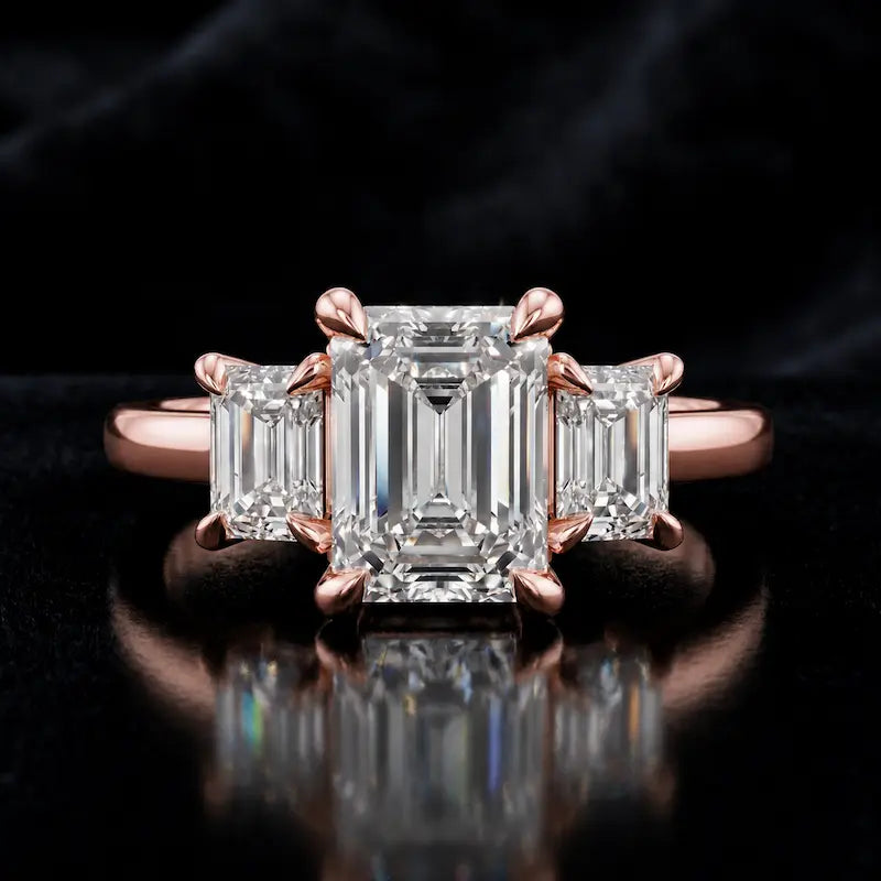 Front view of an emerald-cut lab-grown diamond trilogy engagement ring in 18ct rose gold with matching emerald-cut side diamonds.