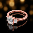 Side view of an emerald-cut three-stone lab-grown diamond engagement ring in 18ct rose gold, highlighting the elevated basket setting.