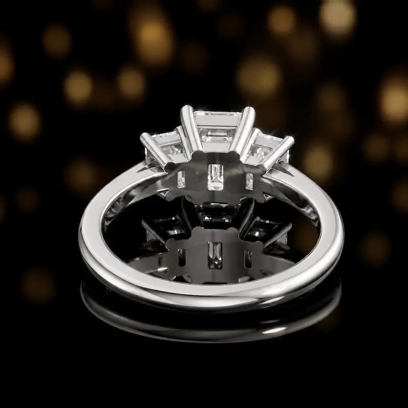 Rear view of an emerald-cut three-stone lab-grown diamond ring in 18ct white gold, showcasing the open basket setting.