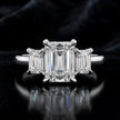 Front view of an emerald-cut lab-grown diamond trilogy engagement ring in 18ct white gold with matching emerald-cut side diamonds.