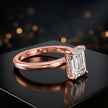 Angled view of 4-claw emerald cut engagement ring with hidden halo in 18kt rose gold