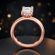 Front view of 4-claw emerald cut engagement ring with hidden halo in 18kt rose gold