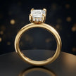 Front view of 4-claw emerald cut engagement ring with hidden halo in 18kt yellow gold