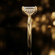 Side profile of 4-claw emerald cut engagement ring with hidden halo in 18kt yellow gold