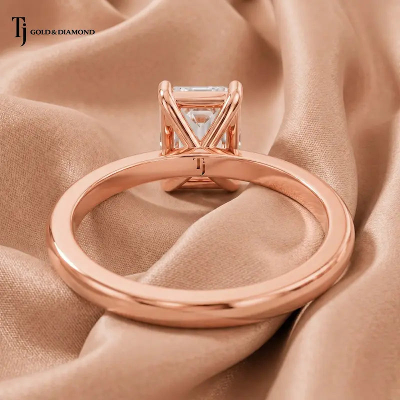 Back view of a 1.5 carat emerald cut lab-grown diamond solitaire engagement ring in 18kt rose gold with a 4-claw setting
