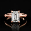 Front view of a 1.5 carat emerald cut diamond solitaire engagement ring in an 18kt rose gold 4 claw setting by TJ Diamond