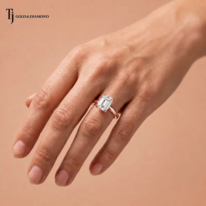 1.5 carat emerald cut lab-grown diamond solitaire engagement ring in 18kt rose gold worn on hand