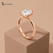 Side angle view of a 1.5 carat emerald cut lab-grown diamond solitaire engagement ring in 18kt rose gold with a 4-claw setting