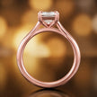Front-on view of a 1.5 carat emerald cut diamond solitaire engagement ring showing the full 18kt rose gold band and 4 claw cathedral setting by TJ Diamond