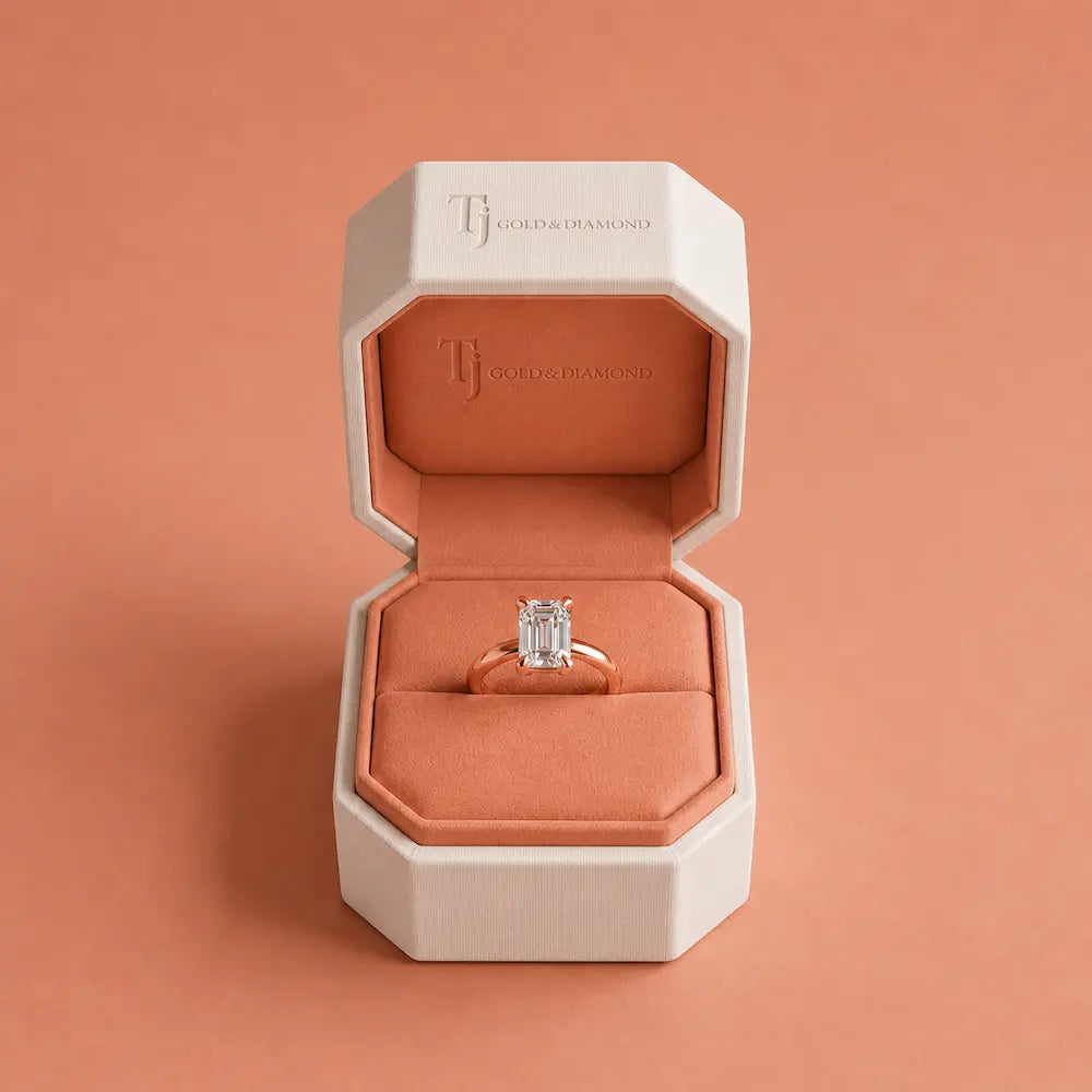 Boxed view of a 1.5 carat emerald cut lab-grown diamond solitaire engagement ring in 18kt rose gold in a TJ Gold & Diamond box