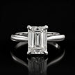 Front view of a 1.5 carat emerald cut diamond solitaire engagement ring in an 18kt white gold 4 claw setting by TJ Diamond