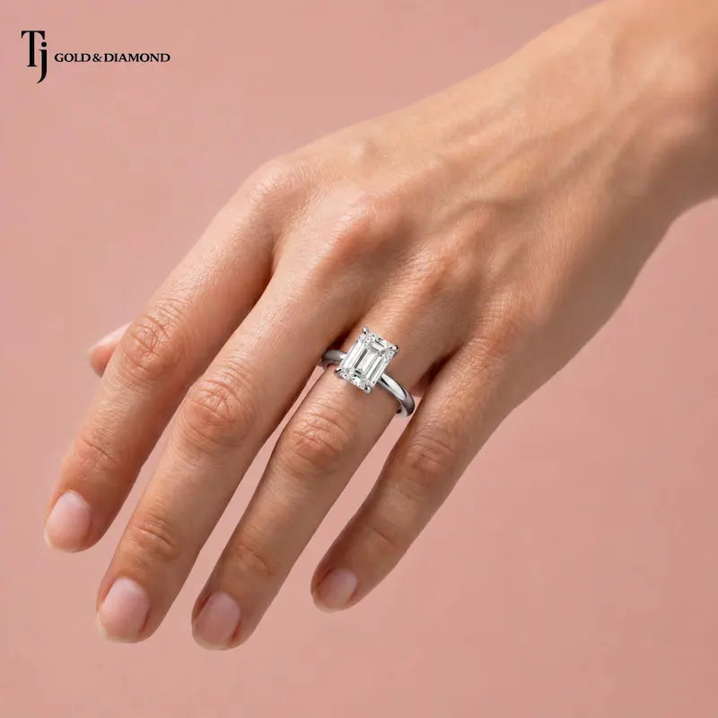 1.5 carat emerald cut lab-grown diamond solitaire engagement ring in 18kt white gold worn on hand