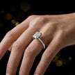 1.5 carat emerald cut diamond solitaire engagement ring in an 18kt white gold 4 claw setting worn on a hand, by TJ Diamond