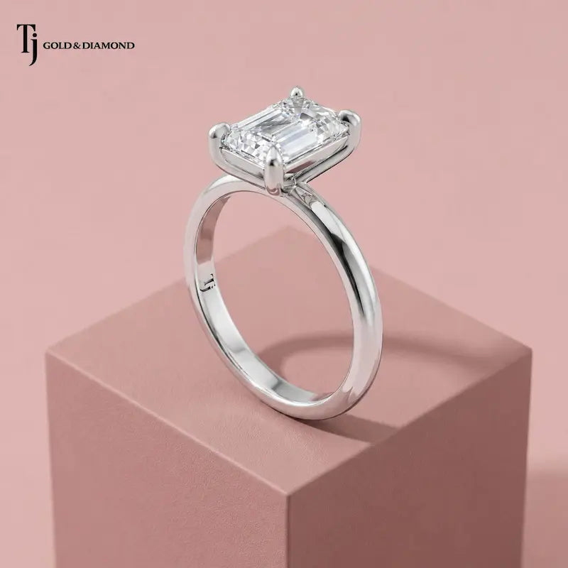 Raised side view of a 1.5 carat emerald cut lab-grown diamond solitaire engagement ring in 18kt white gold with a 4-claw setting