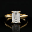 Front view of a 1.5 carat emerald cut diamond solitaire engagement ring in an 18kt yellow gold 4 claw setting by TJ Diamond