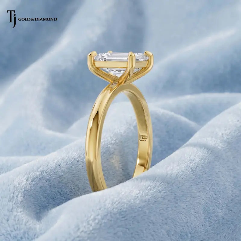 Side angle view of a 1.5 carat emerald cut lab-grown diamond solitaire engagement ring in 18kt yellow gold with a 4-claw setting
