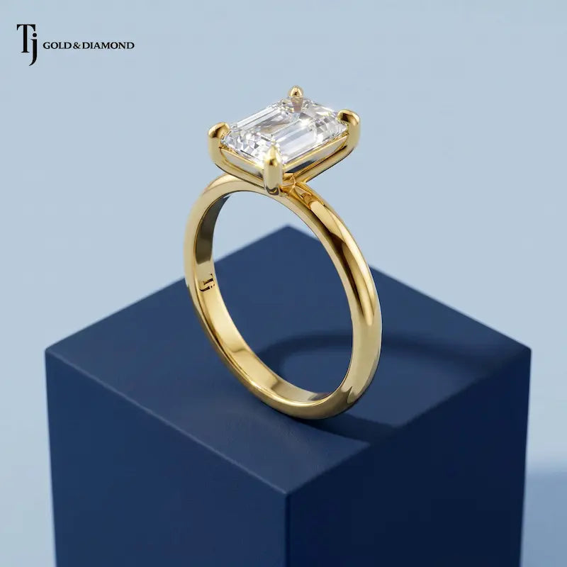 Side profile view of a 1.5 carat emerald cut lab-grown diamond solitaire engagement ring in 18kt yellow gold