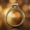 Front-on view of a 1.5 carat emerald cut diamond solitaire engagement ring showing the full 18kt yellow gold band and 4 claw cathedral setting by TJ Diamond