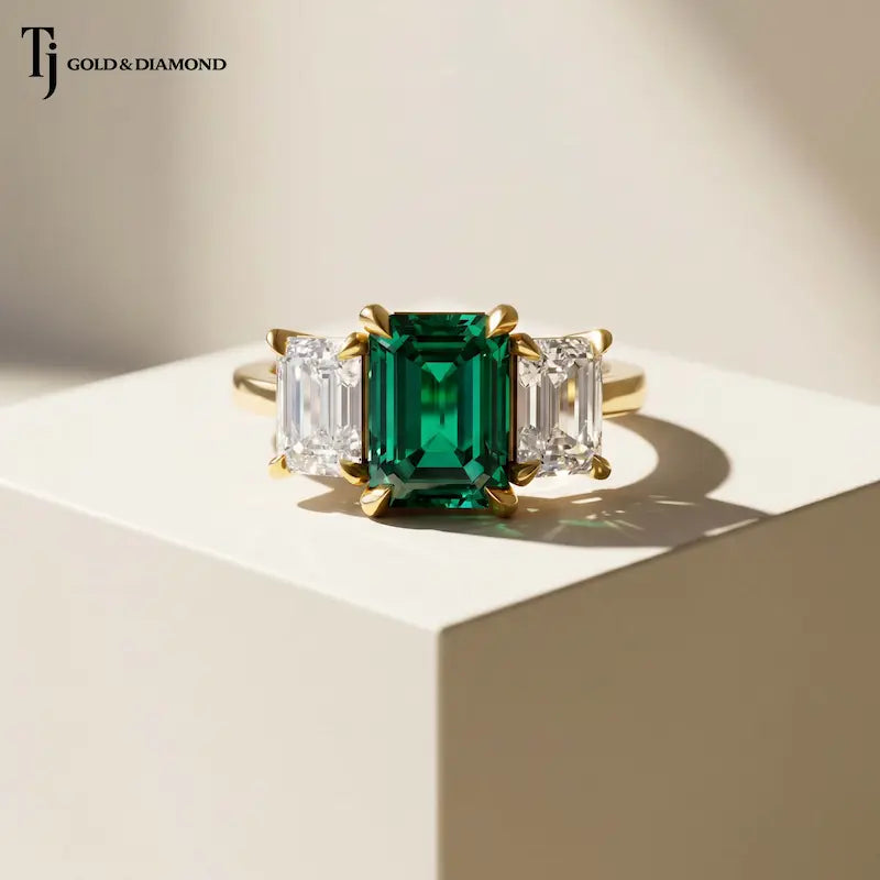 Front View of an Emerald Cut Lab-Created Emerald & Lab-Grown Diamond Trilogy Ring in 18kt yellow gold.