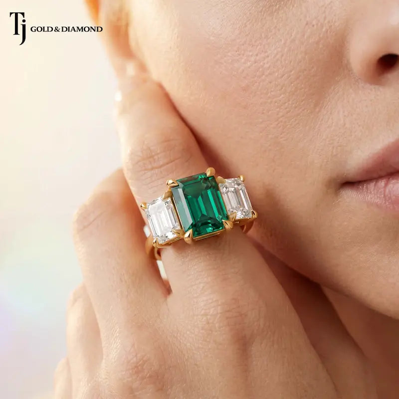 Model wearing an Emerald Cut Lab-Created Emerald & Lab-Grown Diamond Trilogy Ring in 18kt yellow gold.