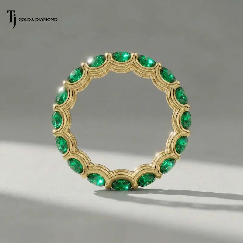 Created emerald full eternity ring in 18kt yellow gold featuring 1.5mm round brilliant lab-created emeralds displayed upright.