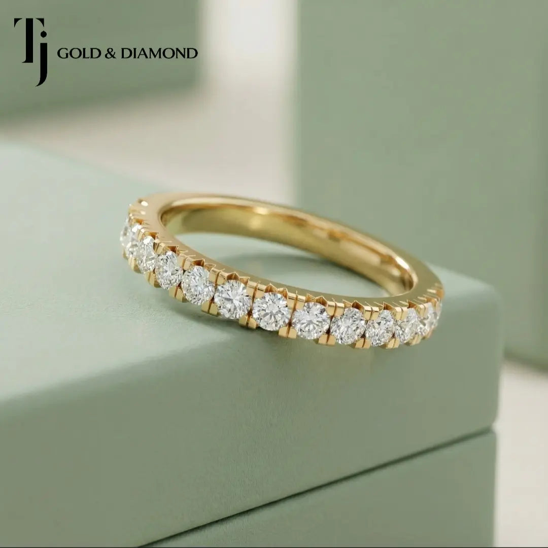 Angled view of Claw Fish Tail Half Eternity diamond wedding band in 18kt yellow gold, round brilliant diamonds in fish tail claw setting