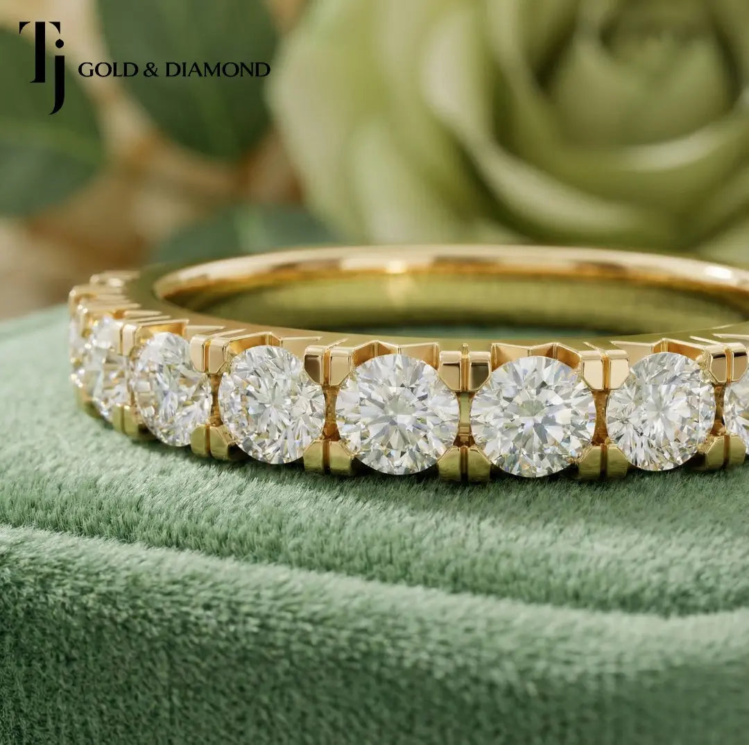Close-up of Claw Fish Tail Half Eternity diamond wedding band in 18kt yellow gold, showing round brilliant diamonds and fish tail claw detail