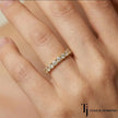 Fish tail setting full eternity diamond wedding band in 18kt yellow gold worn on finger with round brilliant lab-grown diamonds.