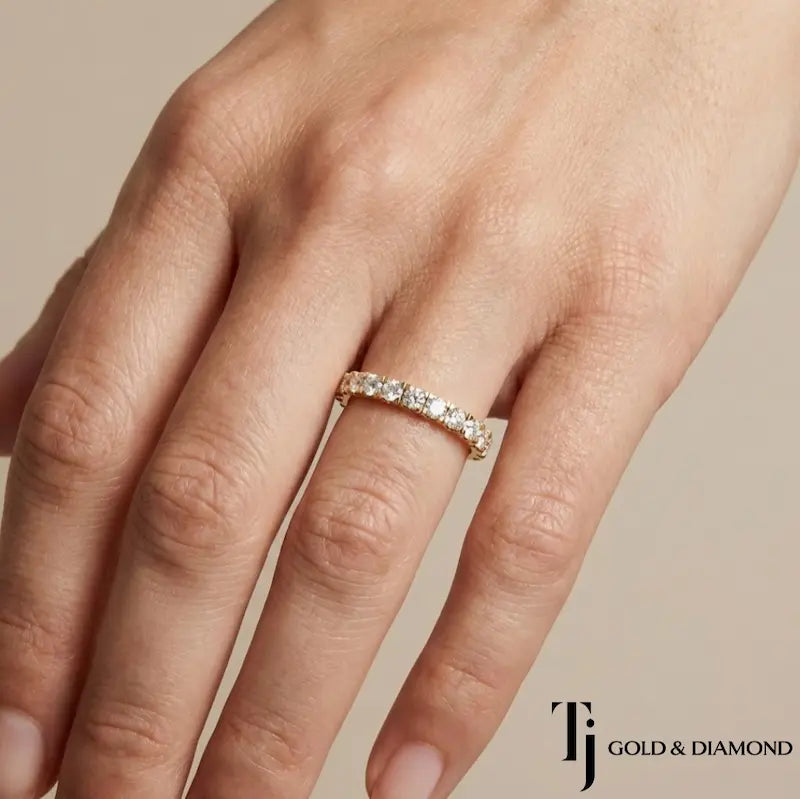 French pavé setting full eternity diamond wedding band in 18kt yellow gold worn on hand with round brilliant lab-grown diamonds.