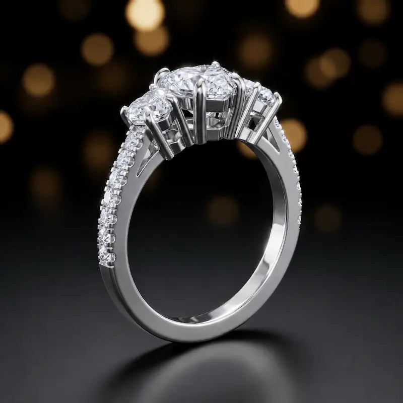 Angled view of a heart cut three-stone lab-grown diamond engagement ring in 18kt white gold with diamond shoulders