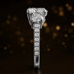 Side profile of a heart cut three-stone lab-grown diamond engagement ring in 18kt white gold showing the diamond band