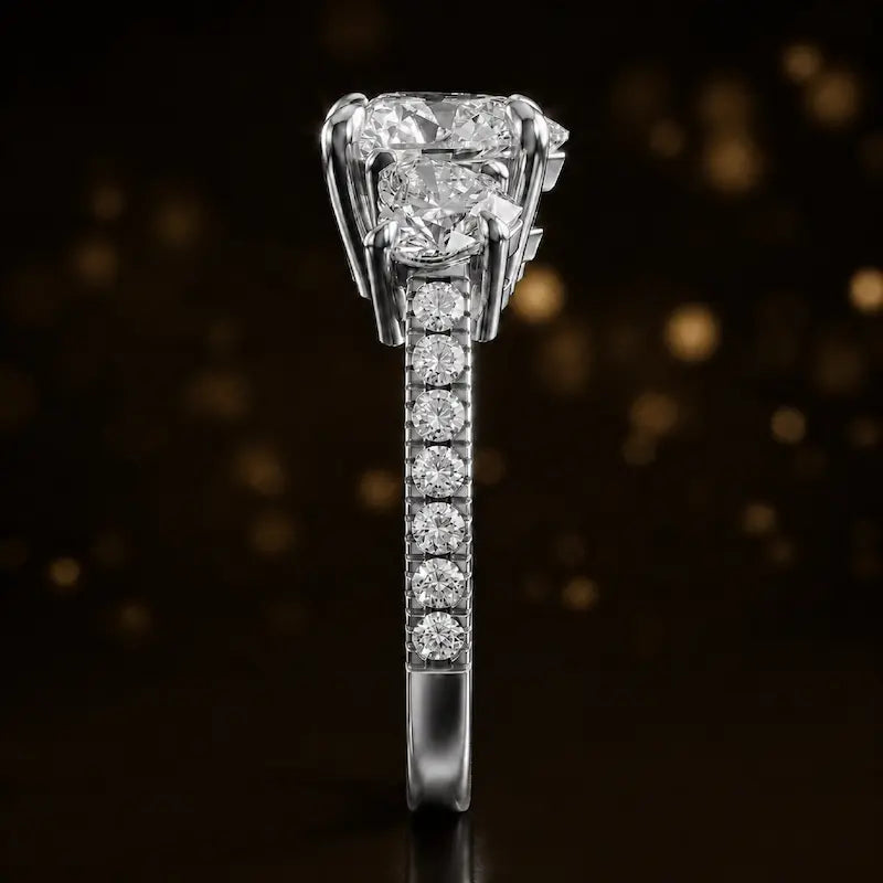 Side profile of a heart cut three-stone lab-grown diamond engagement ring in 18kt white gold showing the diamond band