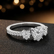 Side view of a heart cut three-stone lab-grown diamond engagement ring in 18kt white gold with diamond shoulders