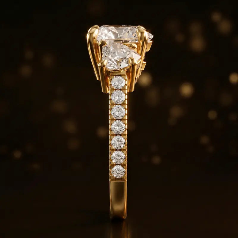 Side profile of a heart cut three-stone lab-grown diamond engagement ring in 18kt yellow gold showing the diamond band