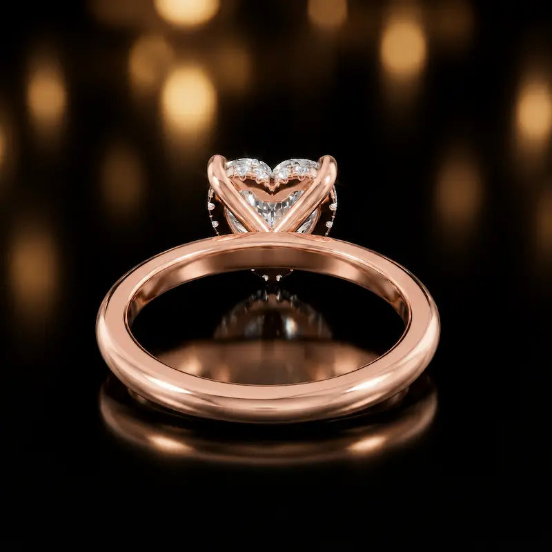 Back view of 4-claw heart cut engagement ring with hidden halo in 18kt rose gold