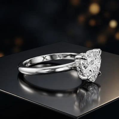 Angled view of 4-claw heart cut engagement ring with hidden halo in 18kt white gold