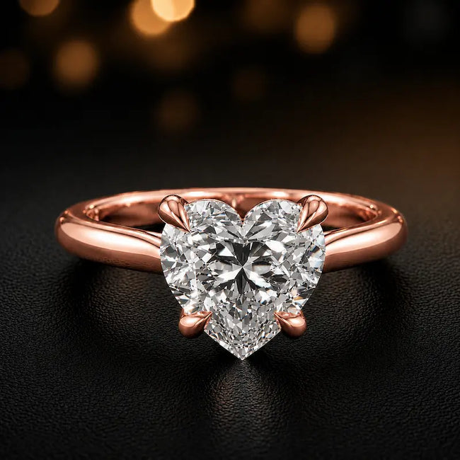 Front view of a 1.5 carat heart cut diamond solitaire engagement ring in an 18kt rose gold 4 claw setting by TJ Diamond