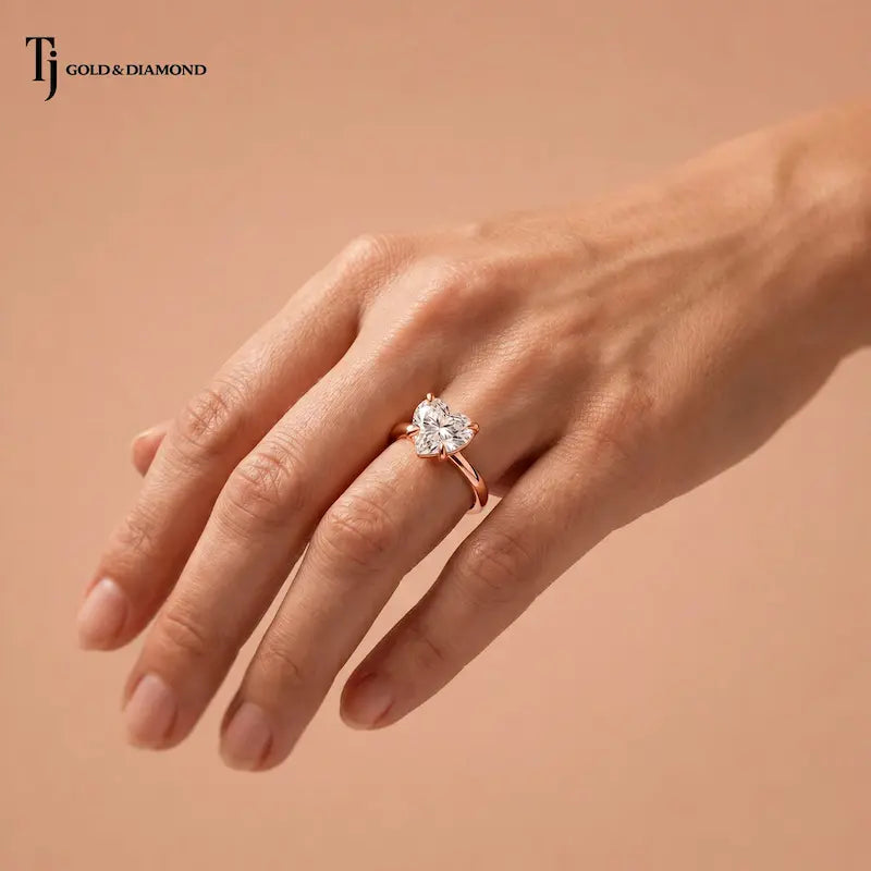  1.5 carat heart cut lab-grown diamond solitaire engagement ring in 18kt rose gold worn on hand
