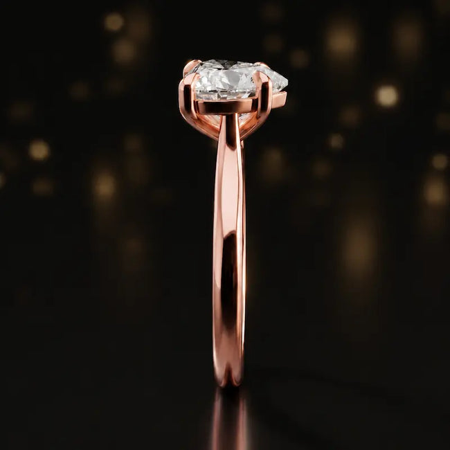 Side profile of a 1.5 carat heart cut diamond solitaire engagement ring showing the cathedral setting and 18kt rose gold band by TJ Diamond