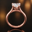 Front-on view of a 1.5 carat heart cut diamond solitaire engagement ring showing the full 18kt rose gold band and 4 claw cathedral setting by TJ Diamond