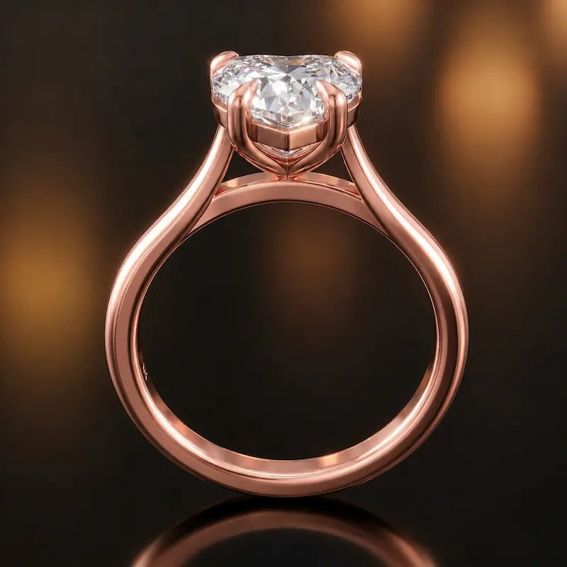 Front-on view of a 1.5 carat heart cut diamond solitaire engagement ring showing the full 18kt rose gold band and 4 claw cathedral setting by TJ Diamond