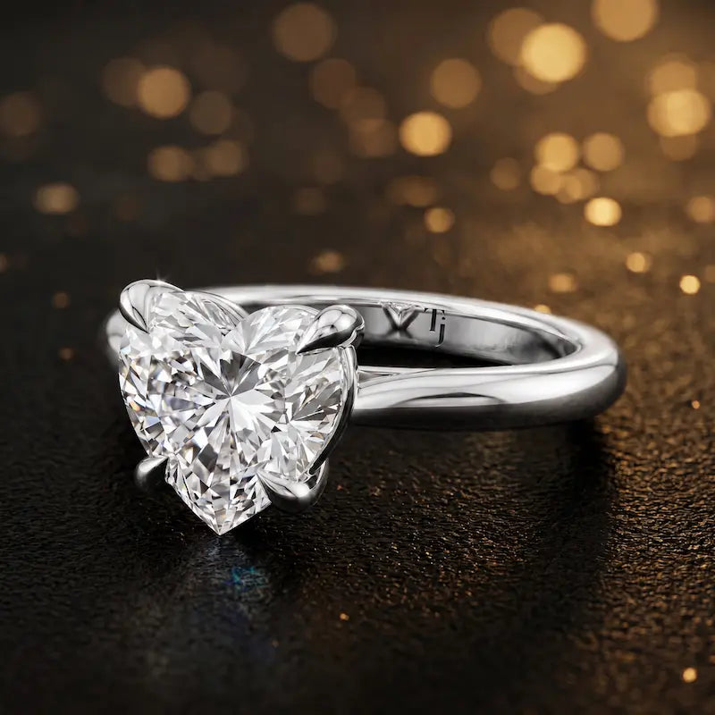 Angled side view of a 1.5 carat heart cut diamond solitaire engagement ring in an 18kt white gold 4 claw setting by TJ Diamond