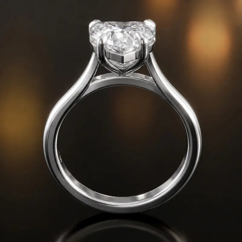 Front-on view of a 1.5 carat heart cut diamond solitaire engagement ring showing the full 18kt white gold band and 4 claw cathedral setting by TJ Diamond
