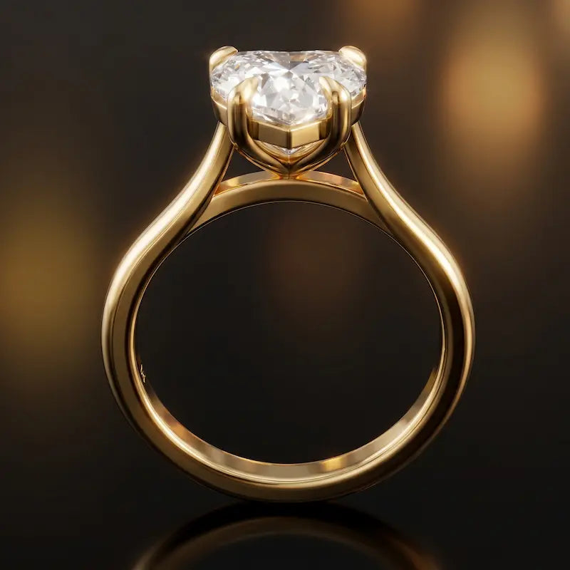 Front-on view of a 1.5 carat heart cut diamond solitaire engagement ring showing the full 18kt yellow gold band and 4 claw cathedral setting by TJ Diamond