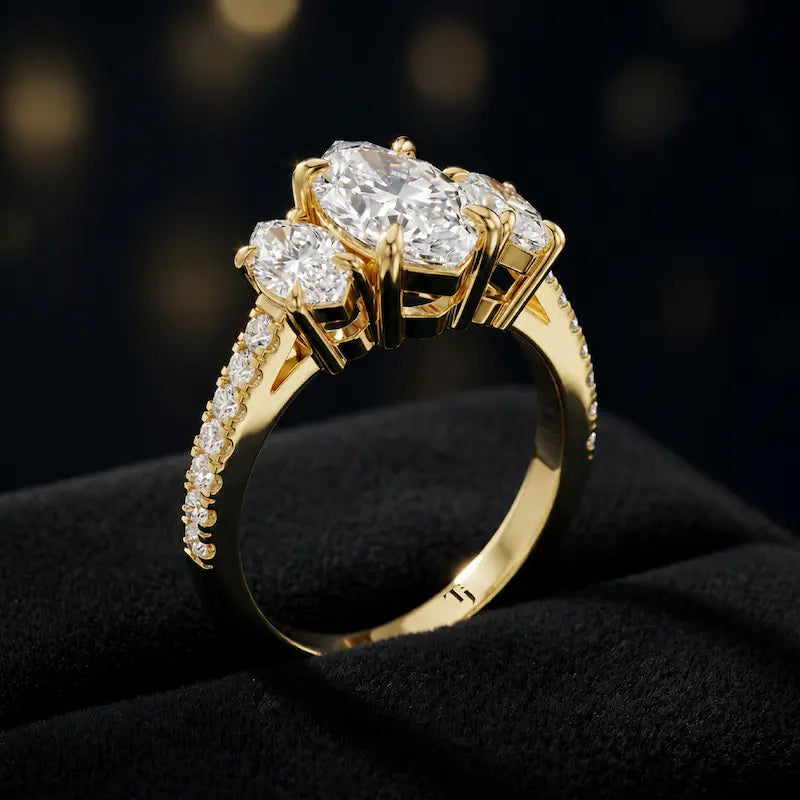 Angled view of a marquise cut three-stone lab-grown diamond engagement ring in 18kt yellow gold with diamond shoulders
