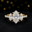 Front view of a marquise cut three-stone lab-grown diamond engagement ring in 18kt yellow gold with diamond shoulders