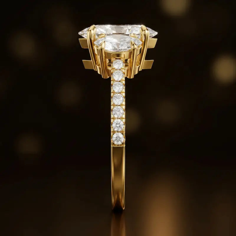 Side profile of a marquise cut three-stone lab-grown diamond engagement ring in 18kt yellow gold showing the diamond band